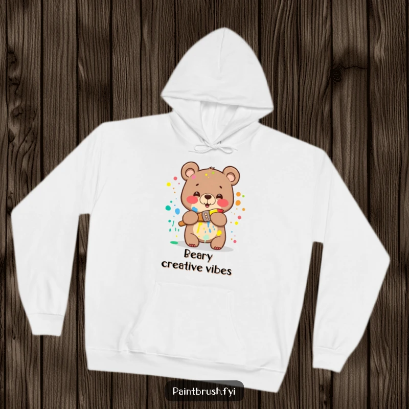 Funny Bear Hoodie: A happy bear splattered with rainbow paint attempting to hug a paintbrush, offering humorous warmth and artistic flair.